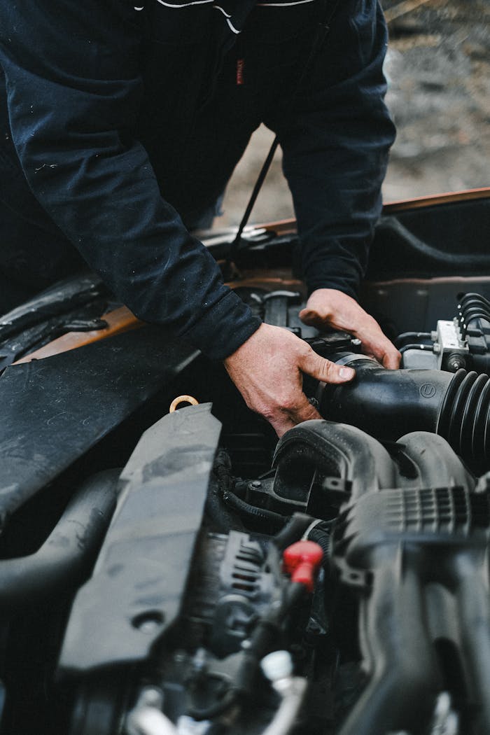 Mastering the First Impression: Your intriguing post title goes here Close-up of a mechanic's hands working on a car engine inside a workshop.